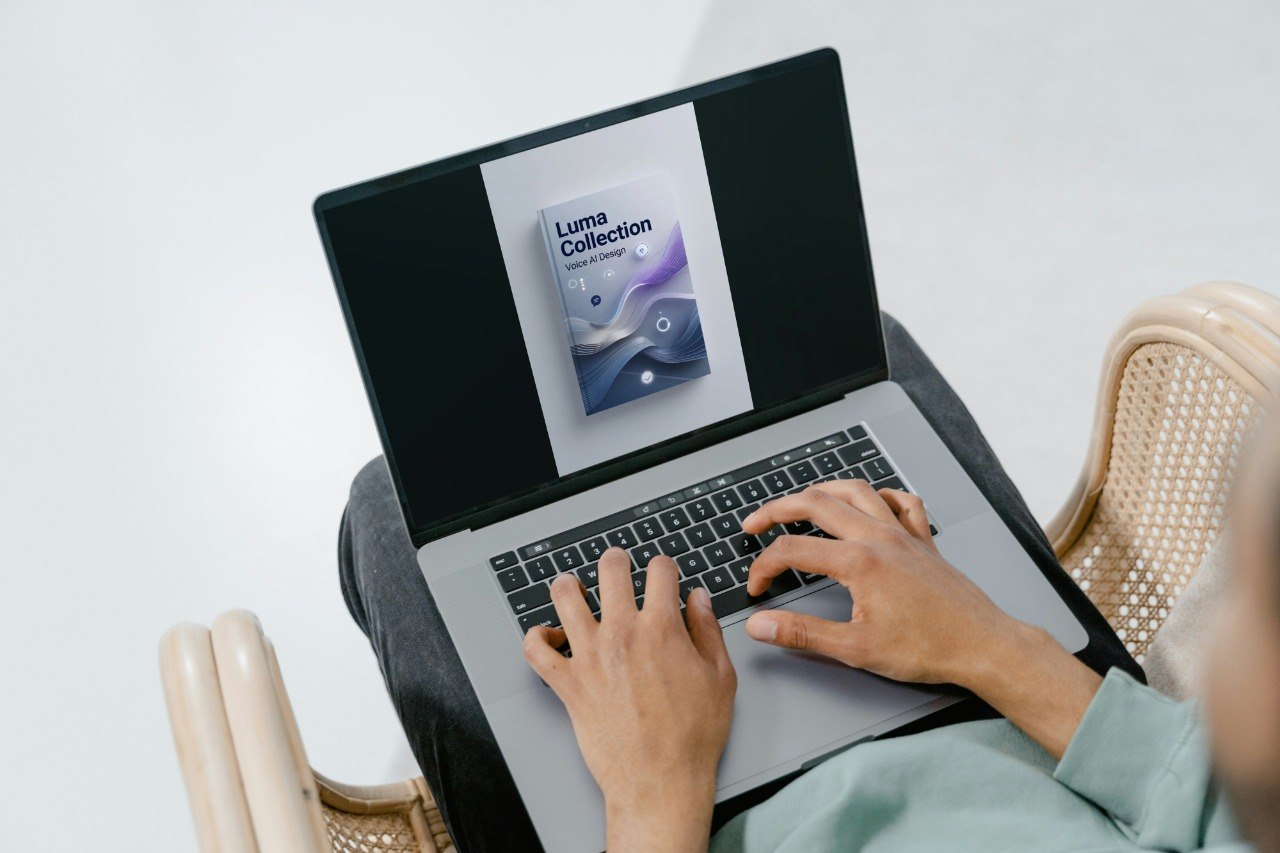 Person using a laptop with a screen displaying 'Luma Collection' on a white background